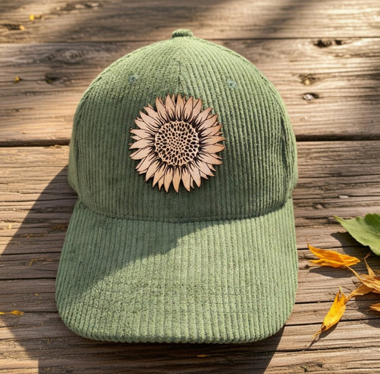 Trendy Tee Co. corduroy cap featuring a sunflower leather patch, stylish and casual accessory for everyday wear.