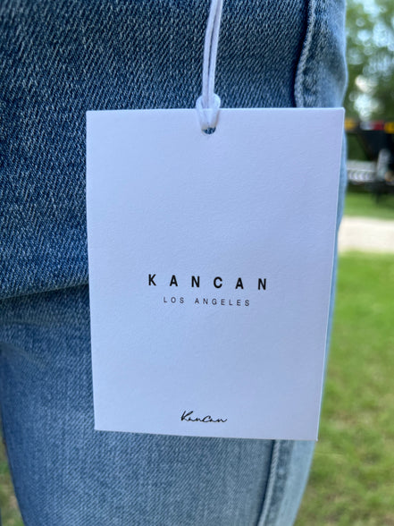 Pair of KanCan Capris with a fitted, casual style and classic denim wash, shown on a person standing outdoors.